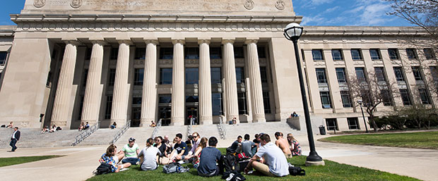 Students sitting on lawn outside Angell Hall University of Michigan