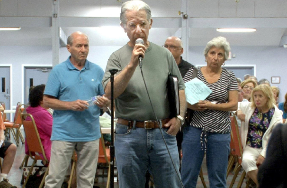 people at a public meeting using microphone