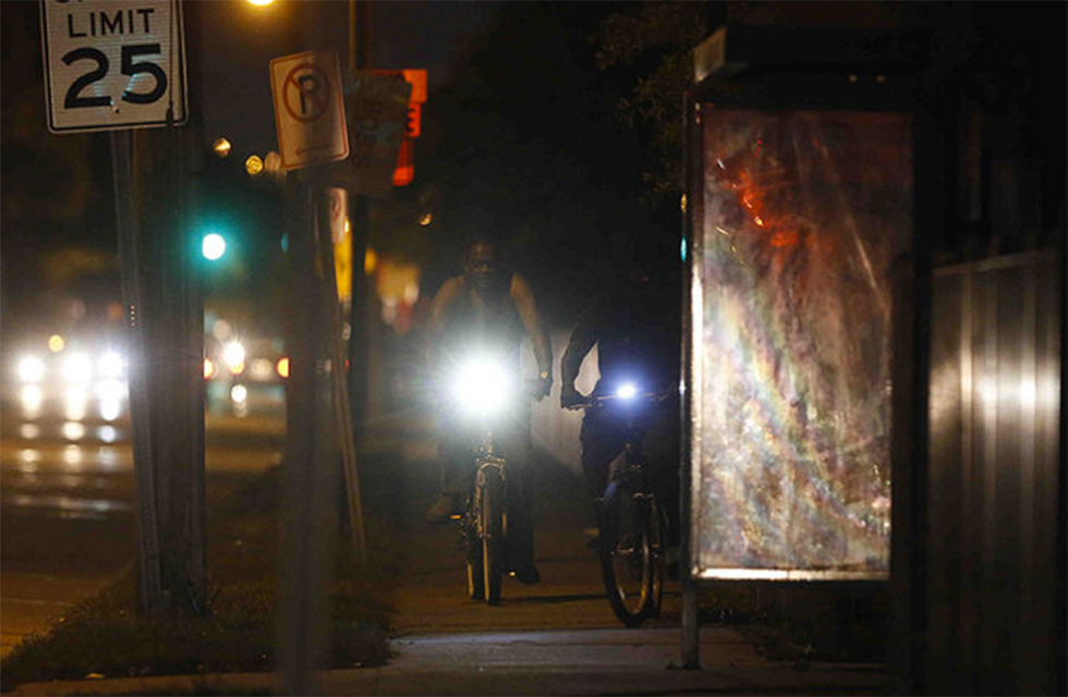 Bicyclists ride at night along Main Street in West Tampa